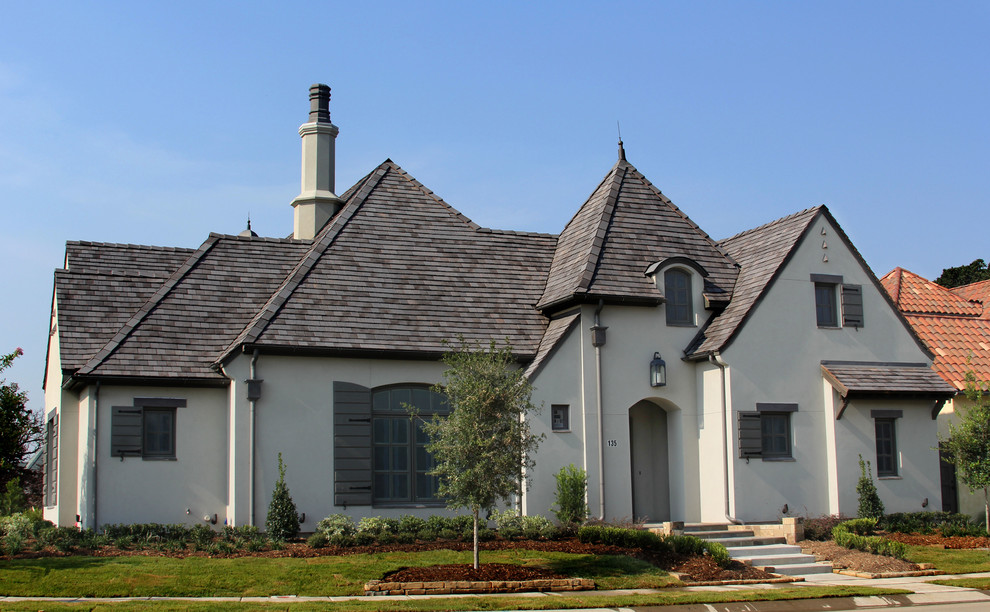 Mid-sized one-storey stucco grey exterior in Dallas.