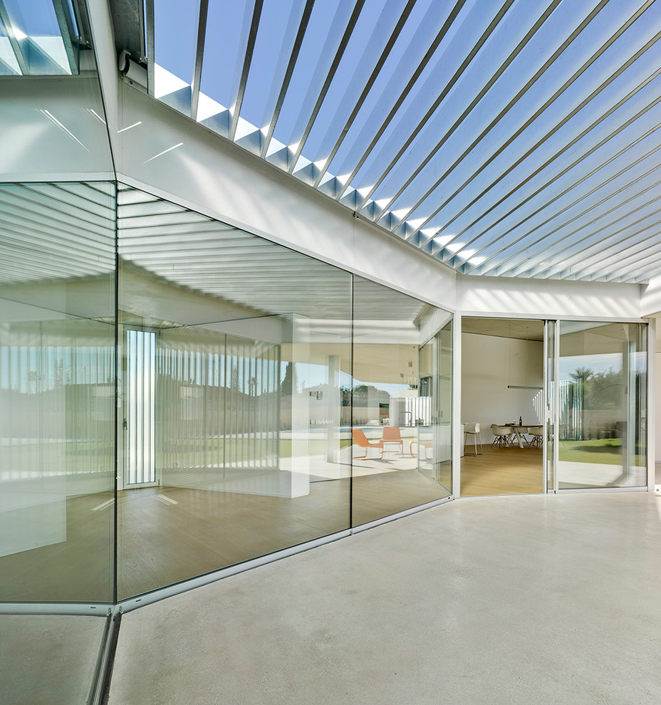 Ejemplo de terraza actual de tamaño medio en patio trasero con toldo