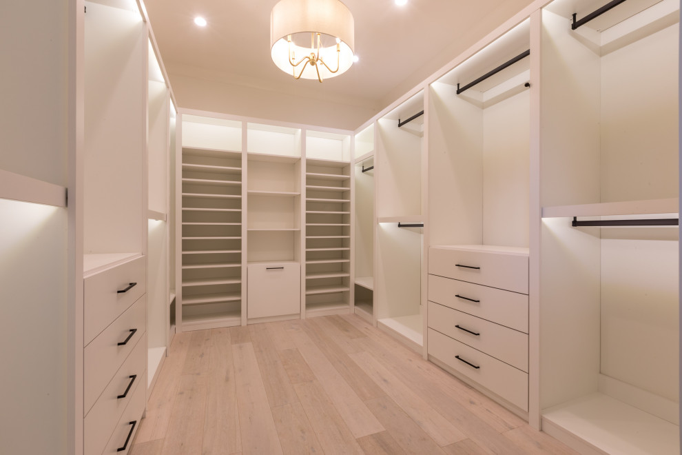 Стильный дизайн: встроенный шкаф среднего размера в стиле неоклассика (современная классика) с плоскими фасадами, белыми фасадами и светлым паркетным полом - последний тренд