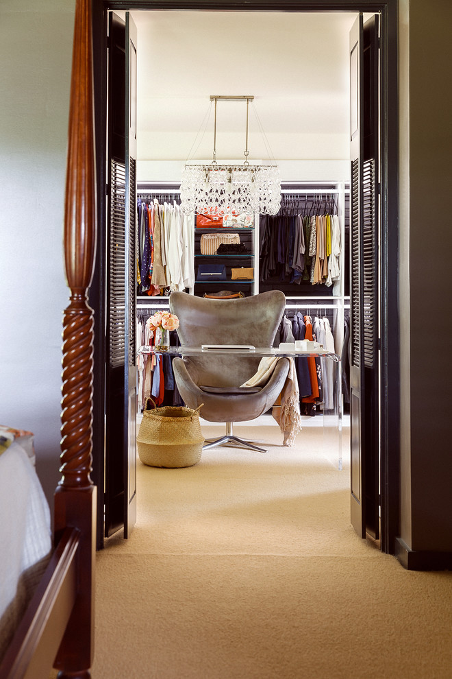 This is an example of a large midcentury women's dressing room in Houston with open cabinets, white cabinets, carpet and beige floor.