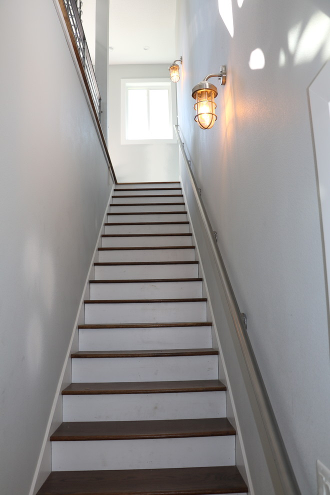 Inspiration for a mid-sized beach style wood straight staircase in Orlando with painted wood risers and metal railing.