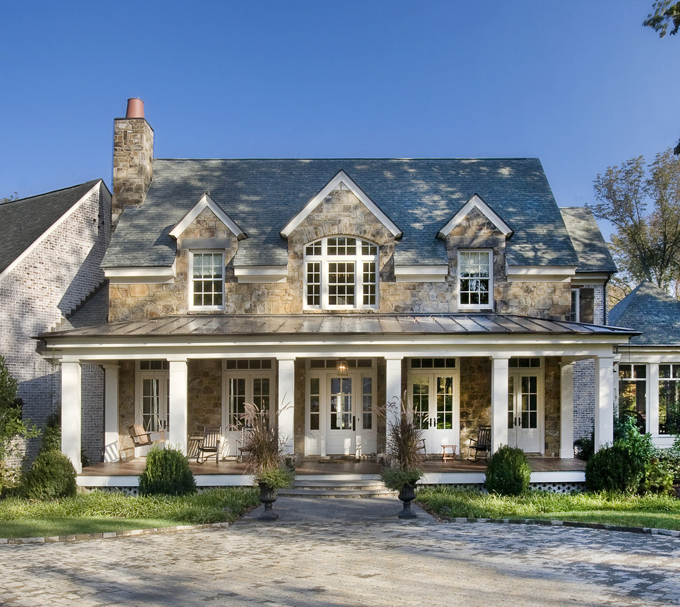 This is an example of a large traditional two-storey brown house exterior in Nashville with stone veneer, a gable roof and a shingle roof.