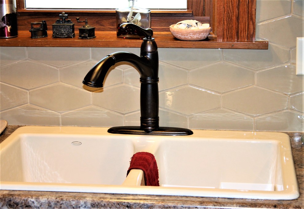 Inspiration for a mid-sized rustic l-shaped vinyl floor and beige floor eat-in kitchen remodel with a farmhouse sink, raised-panel cabinets, medium tone wood cabinets, laminate countertops, beige backsplash, cement tile backsplash, stainless steel appliances, a peninsula and beige countertops
