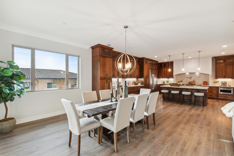 This is an example of an expansive contemporary open plan dining room in San Diego with white walls, medium hardwood flooring and brown floors.