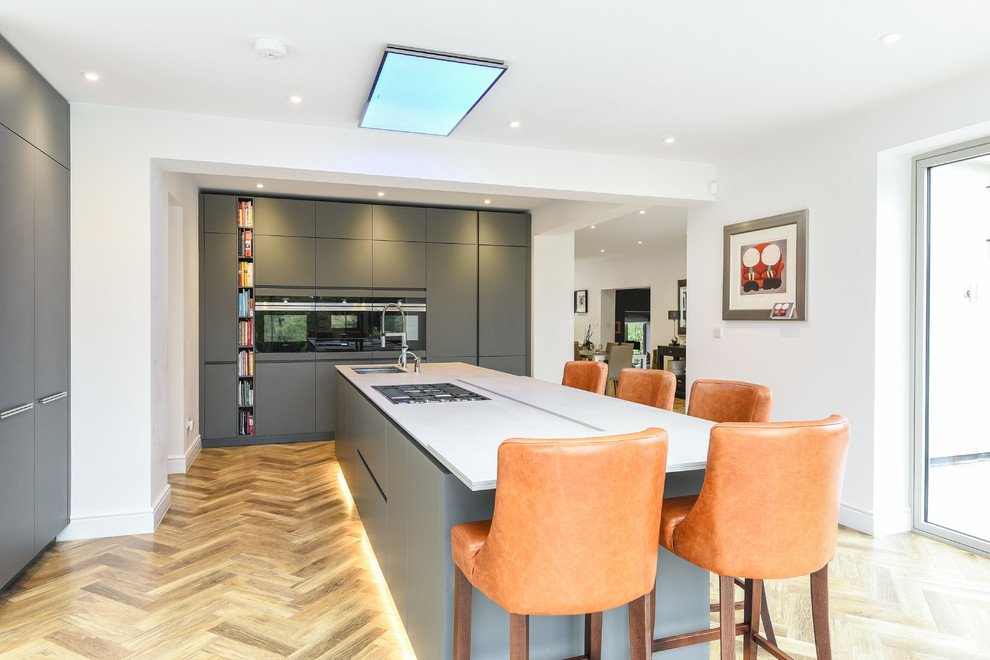 Design ideas for a contemporary l-shaped eat-in kitchen in Surrey with an undermount sink, flat-panel cabinets, grey cabinets, with island and beige floor.