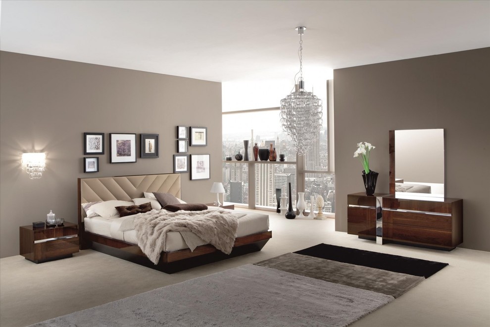 This is an example of a large modern master bedroom in New York with brown walls, carpet and beige floor.