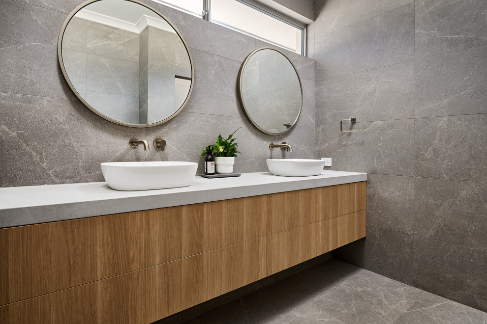 Design ideas for a medium sized contemporary ensuite bathroom in Perth with light wood cabinets, grey tiles, ceramic tiles, ceramic flooring, a vessel sink, engineered stone worktops, grey floors, grey worktops, double sinks, a floating vanity unit and flat-panel cabinets.