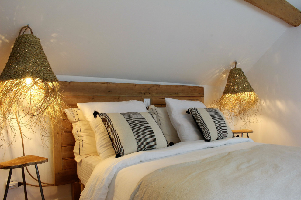 Imagen de dormitorio principal actual de tamaño medio sin chimenea con paredes blancas, suelo de madera clara, suelo marrón, vigas vistas y boiserie