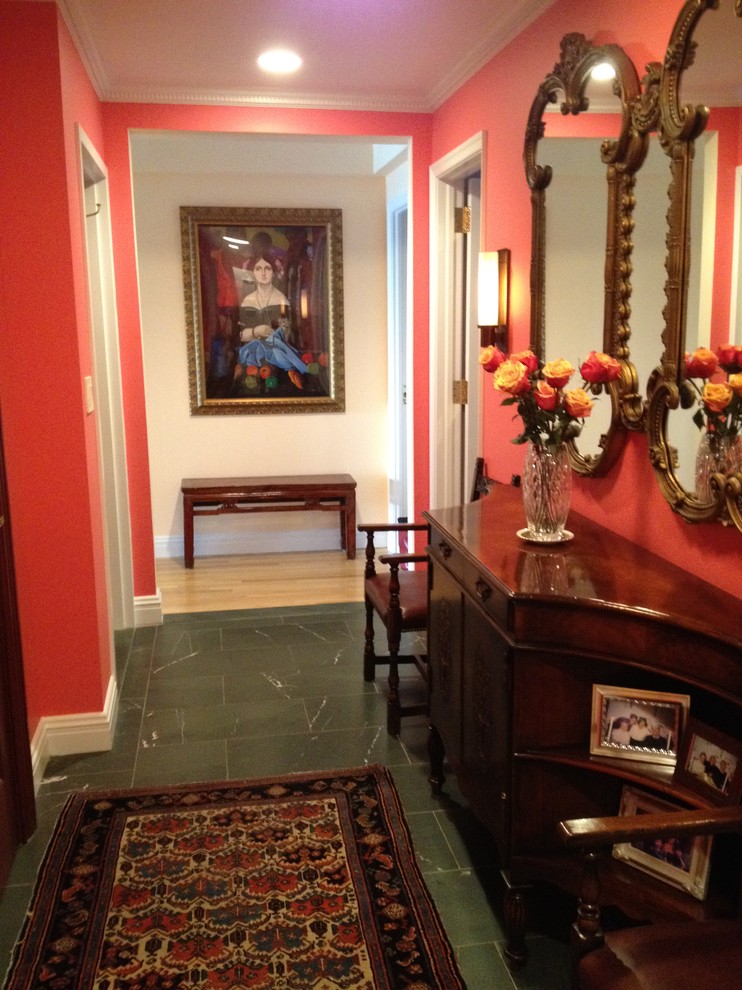 This is an example of a small traditional entry hall in New York with red walls and marble floors.