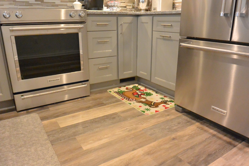 Eat-in kitchen - small transitional u-shaped vinyl floor and brown floor eat-in kitchen idea in DC Metro with an undermount sink, shaker cabinets, gray cabinets, granite countertops, gray backsplash, mosaic tile backsplash, stainless steel appliances, a peninsula and gray countertops