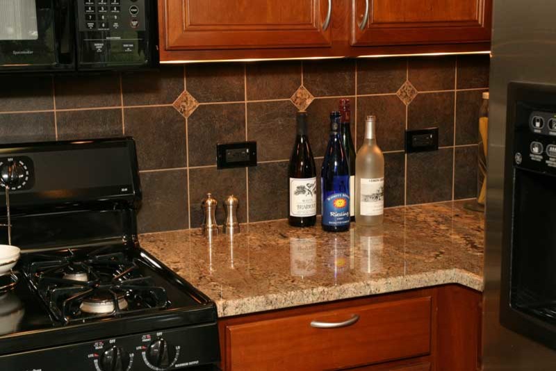 Example of a transitional u-shaped medium tone wood floor kitchen pantry design in Chicago with raised-panel cabinets, medium tone wood cabinets and granite countertops