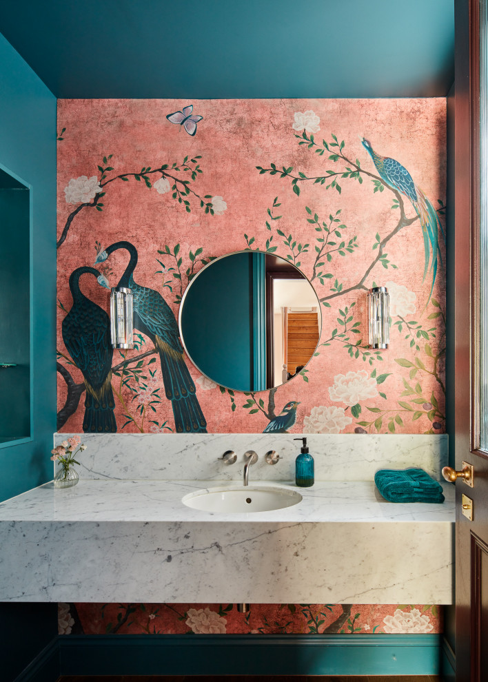 Foto de cuarto de baño único y a medida contemporáneo pequeño con sanitario de pared, paredes azules, suelo de madera en tonos medios, lavabo integrado, encimera de mármol, encimeras blancas y papel pintado