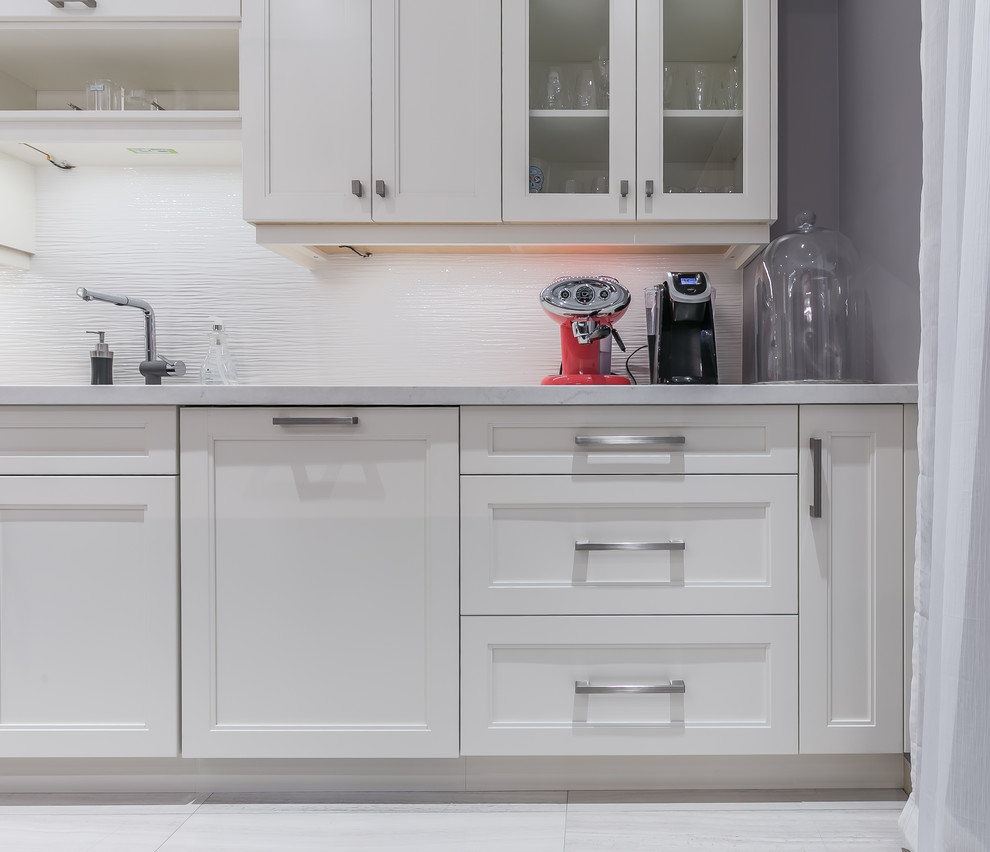 Inspiration for a mid-sized transitional l-shaped porcelain tile eat-in kitchen remodel in Toronto with a drop-in sink, recessed-panel cabinets, white cabinets, quartz countertops, stainless steel appliances and an island