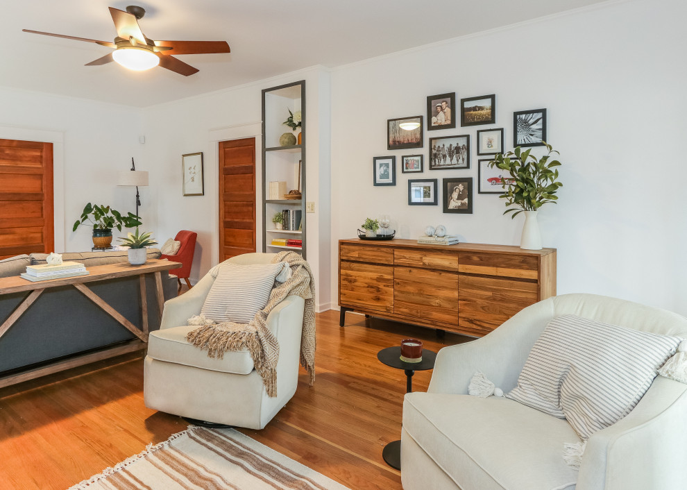 This is an example of a small eclectic enclosed living room in Seattle with white walls, medium hardwood floors, a standard fireplace, a tile fireplace surround, a freestanding tv and brown floor.