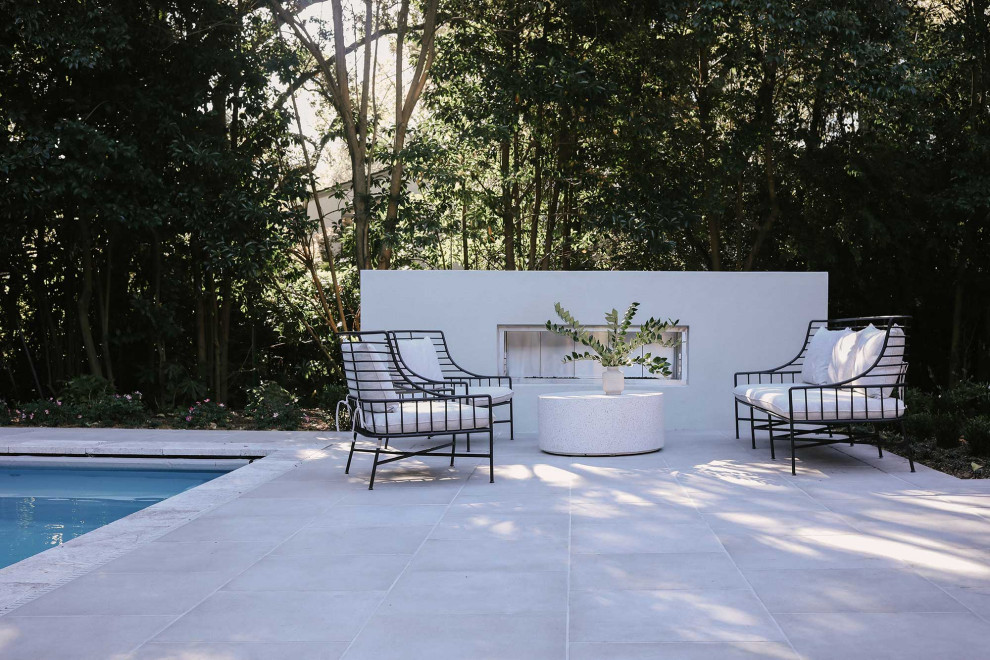 Foto di una grande piscina monocorsia moderna rettangolare dietro casa con paesaggistica bordo piscina e pavimentazioni in pietra naturale