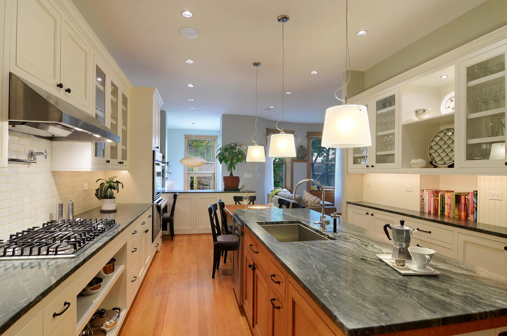 Design ideas for a contemporary u-shaped open plan kitchen in Chicago with an undermount sink, beaded inset cabinets, marble benchtops, white splashback, ceramic splashback, stainless steel appliances, medium hardwood floors and with island.