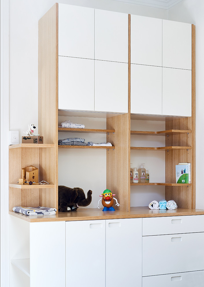 This is an example of a small contemporary gender-neutral nursery in Sydney with white walls and carpet.