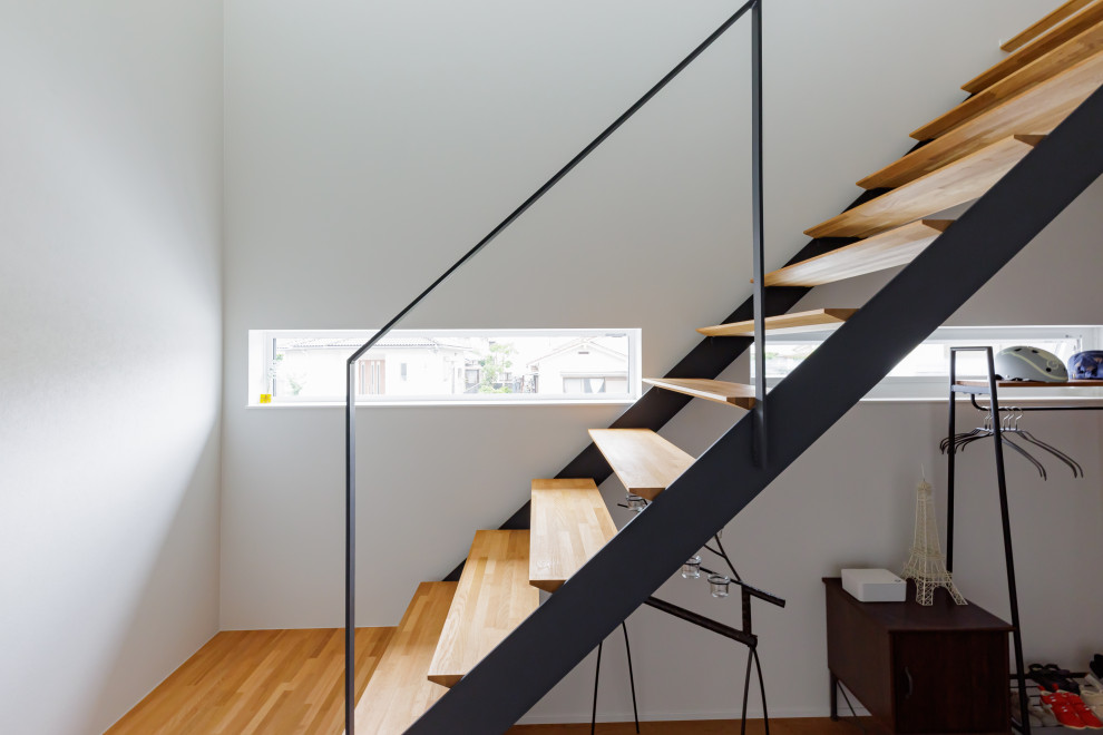 Imagen de escalera suspendida escandinava con escalones de madera, barandilla de metal y papel pintado