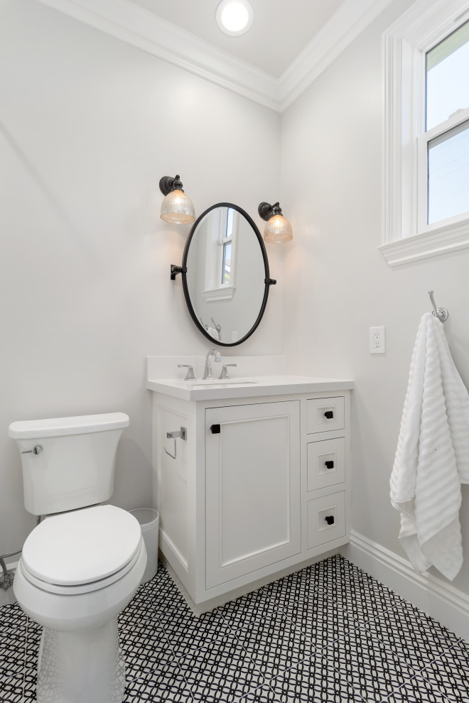 This is an example of a small beach style 3/4 bathroom in Orange County with recessed-panel cabinets, light wood cabinets, an alcove shower, a one-piece toilet, white tile, ceramic tile, white walls, ceramic floors, an undermount sink, granite benchtops, multi-coloured floor, white benchtops, a single vanity, a freestanding vanity and a shower curtain.