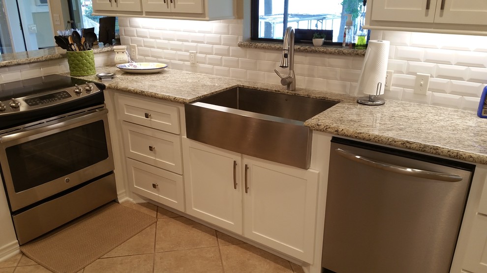 Inspiration for a large transitional galley eat-in kitchen in Houston with a farmhouse sink, shaker cabinets, white cabinets, granite benchtops, white splashback, subway tile splashback, stainless steel appliances, ceramic floors and no island.