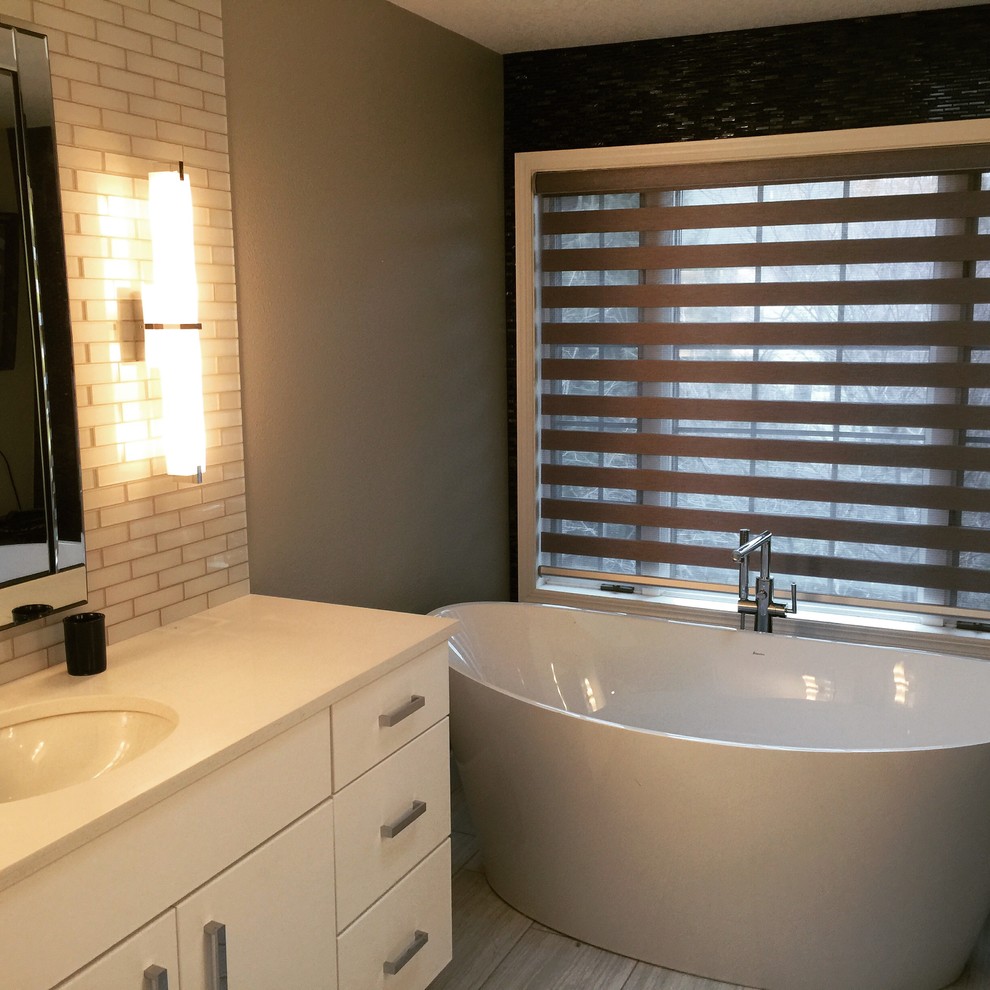 Freestanding bathtub - mid-sized transitional master white tile and subway tile porcelain tile and gray floor freestanding bathtub idea with flat-panel cabinets, gray walls, an undermount sink, quartzite countertops and white cabinets
