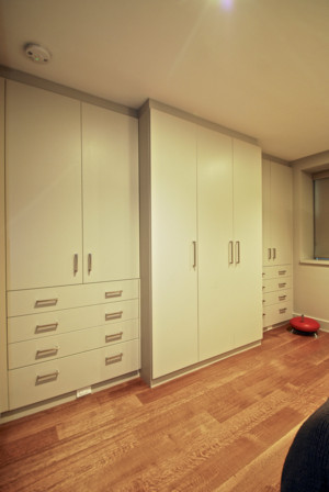 Foto på ett mellanstort funkis huvudsovrum, med beige väggar, mellanmörkt trägolv och brunt golv