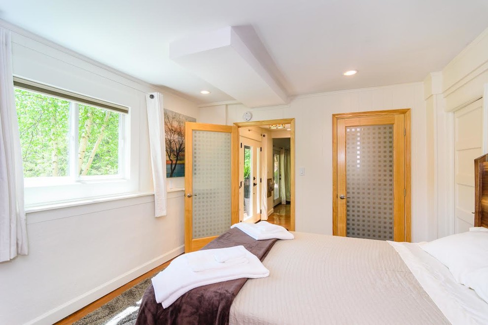 Mid-sized transitional master bedroom in Other with white walls, concrete floors and beige floor.