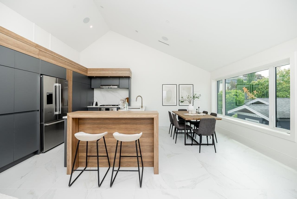 Kitchen pantry - mid-sized transitional u-shaped ceramic tile, multicolored floor and vaulted ceiling kitchen pantry idea in Vancouver with an undermount sink, flat-panel cabinets, gray cabinets, quartzite countertops, multicolored backsplash, ceramic backsplash, stainless steel appliances, an island and white countertops