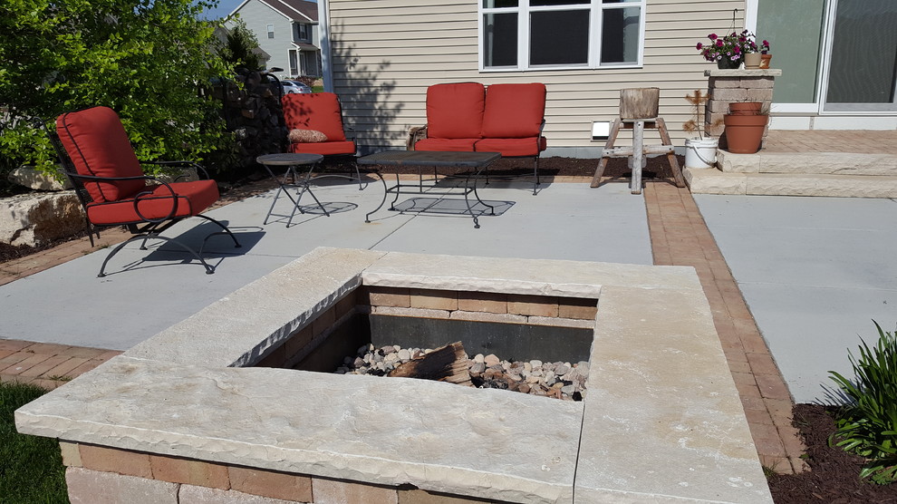 Photo of a mid-sized contemporary backyard patio in Milwaukee with a fire feature, natural stone pavers and no cover.