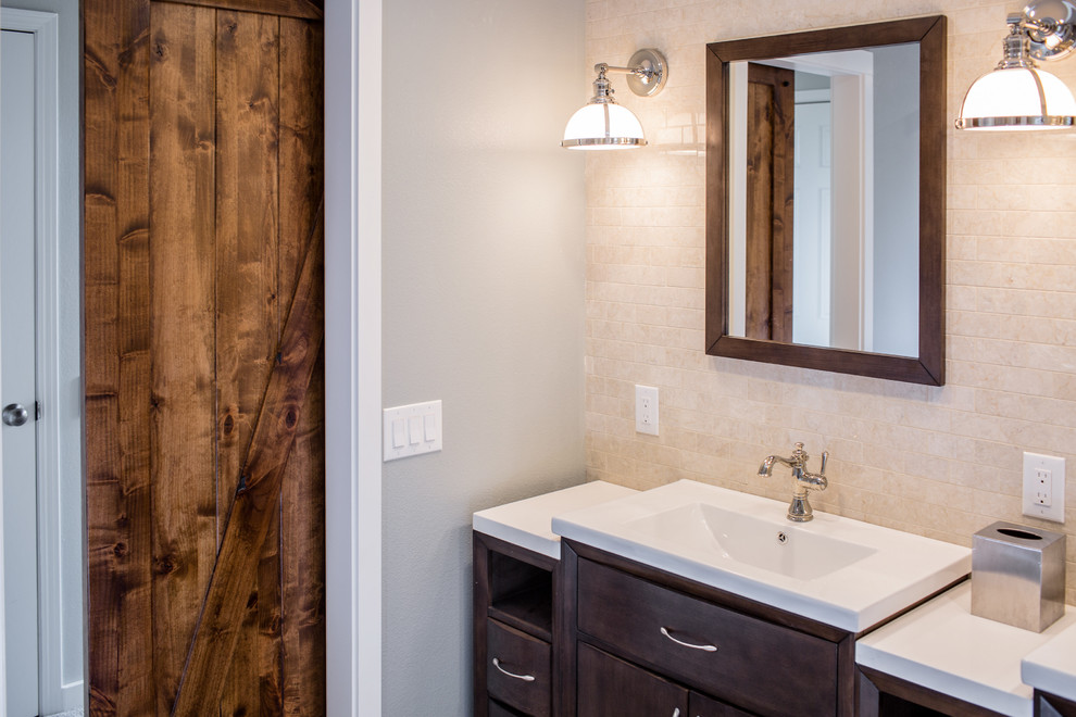 This is an example of a large traditional master bathroom in Denver with flat-panel cabinets, dark wood cabinets, an alcove shower, a one-piece toilet, beige tile, ceramic tile, grey walls, porcelain floors, an integrated sink, engineered quartz benchtops, brown floor and a hinged shower door.