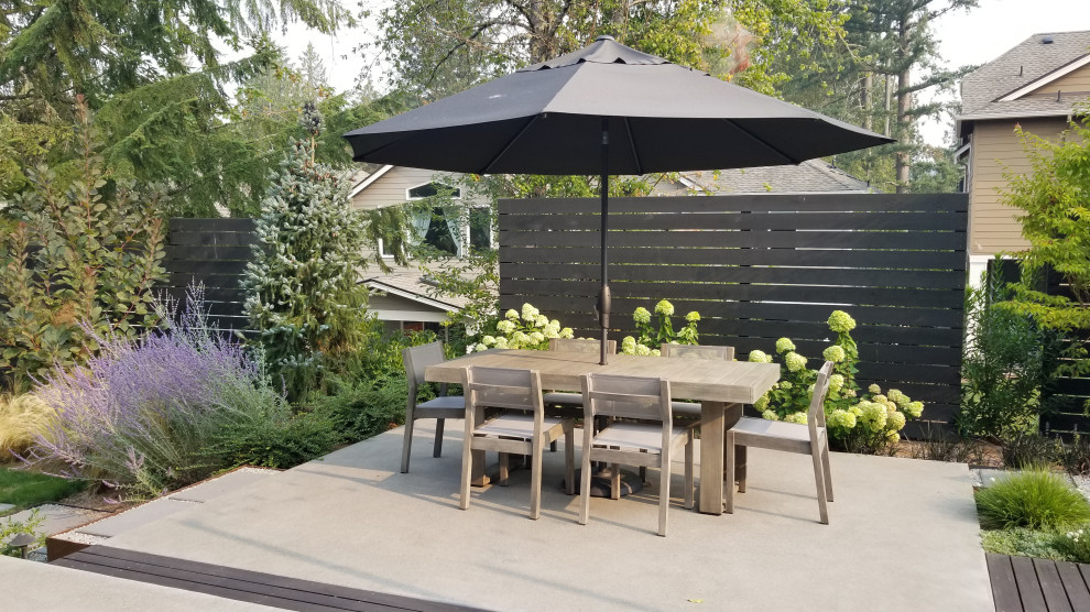 Contemporary patio in Seattle with concrete slab.