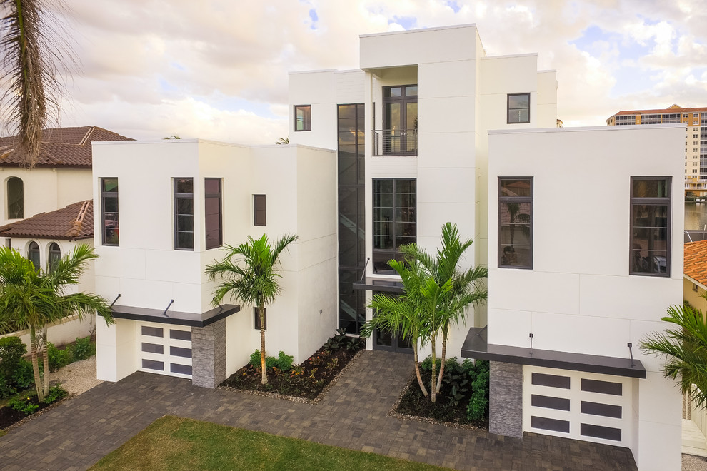 Large modern white three-story stucco exterior home idea
