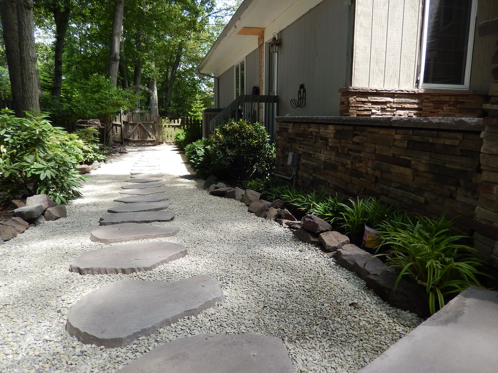 This is an example of a mid-sized contemporary backyard patio in Newark with a fire feature and concrete pavers.