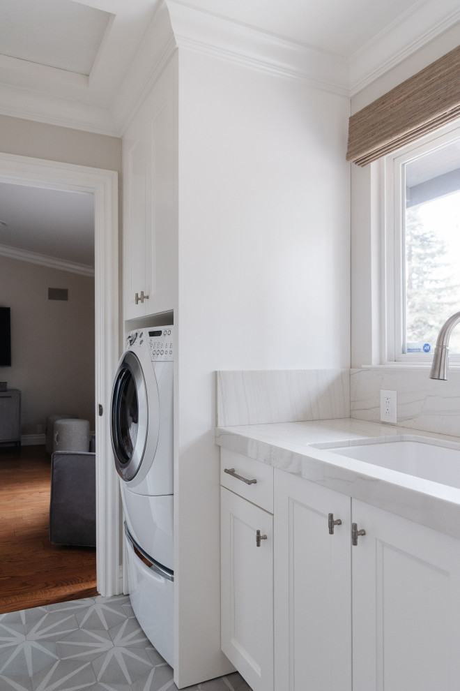 Small transitional galley utility room in San Francisco with a drop-in sink, shaker cabinets, white cabinets, quartzite benchtops, brown walls, ceramic floors, a side-by-side washer and dryer, beige floor and white benchtop.