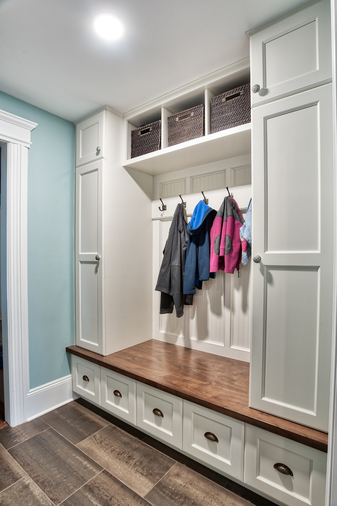 Design ideas for a mid-sized country mudroom in New York with blue walls, brown floor, ceramic floors and a single front door.