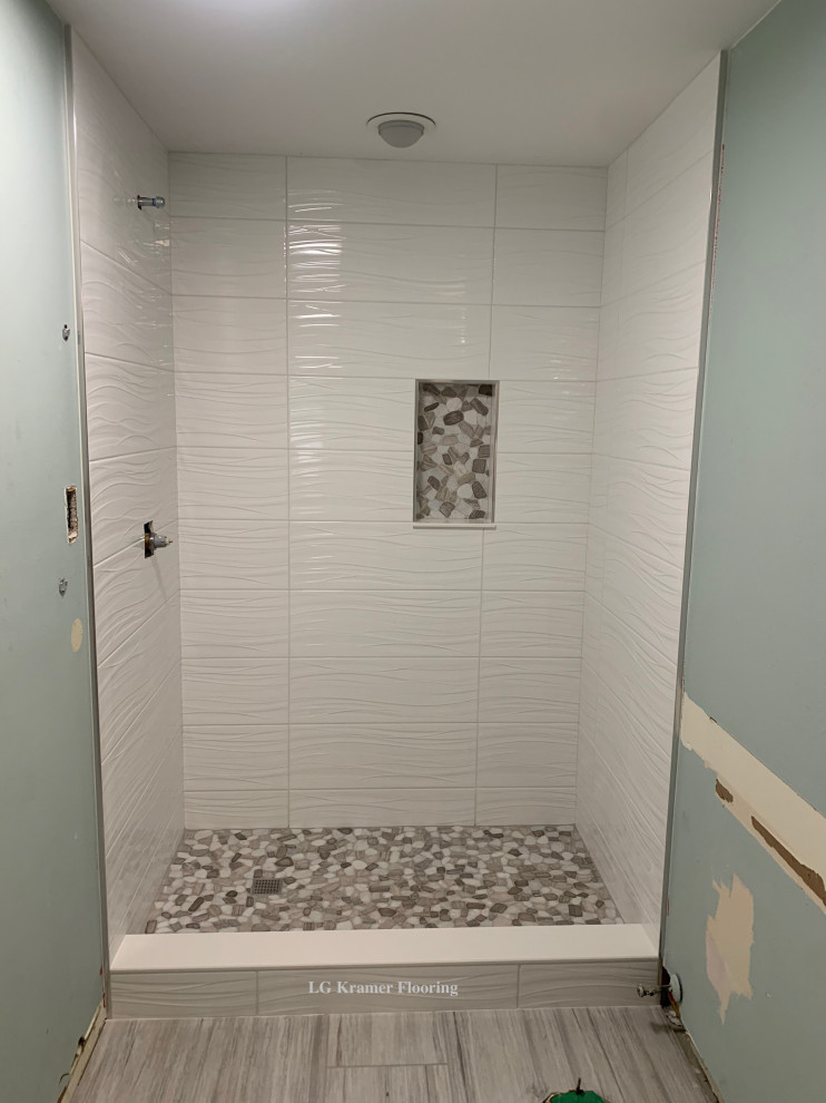 Exempel på ett mellanstort en-suite badrum, med vit kakel, porslinskakel, blå väggar, klinkergolv i småsten, grått golv och dusch med skjutdörr