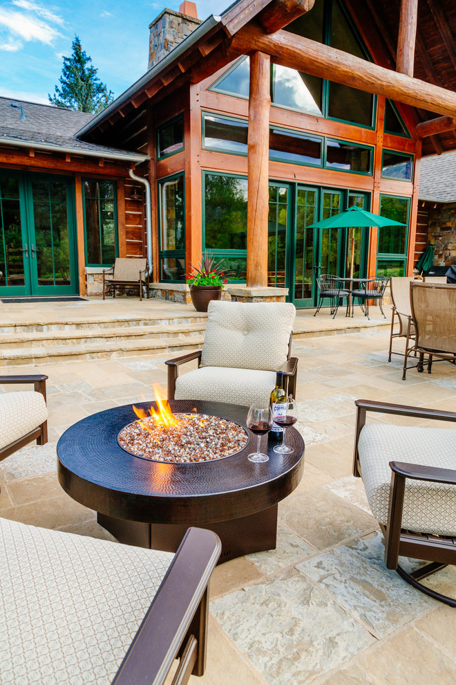 Large country backyard patio in Denver with a fire feature, tile and a roof extension.