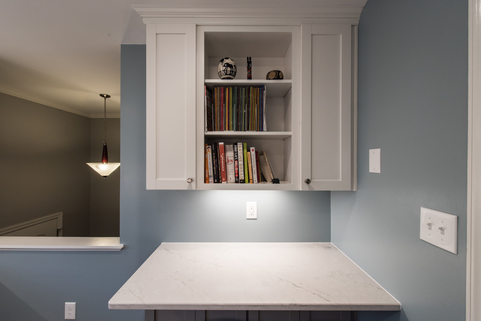 Inspiration for a mid-sized transitional l-shaped eat-in kitchen in DC Metro with an undermount sink, shaker cabinets, white cabinets, quartzite benchtops, white splashback, porcelain splashback, porcelain floors, a peninsula and grey floor.