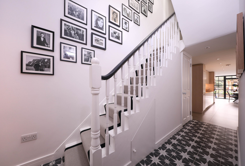 Kleiner Moderner Flur mit weißer Wandfarbe, braunem Holzboden und grauem Boden in London