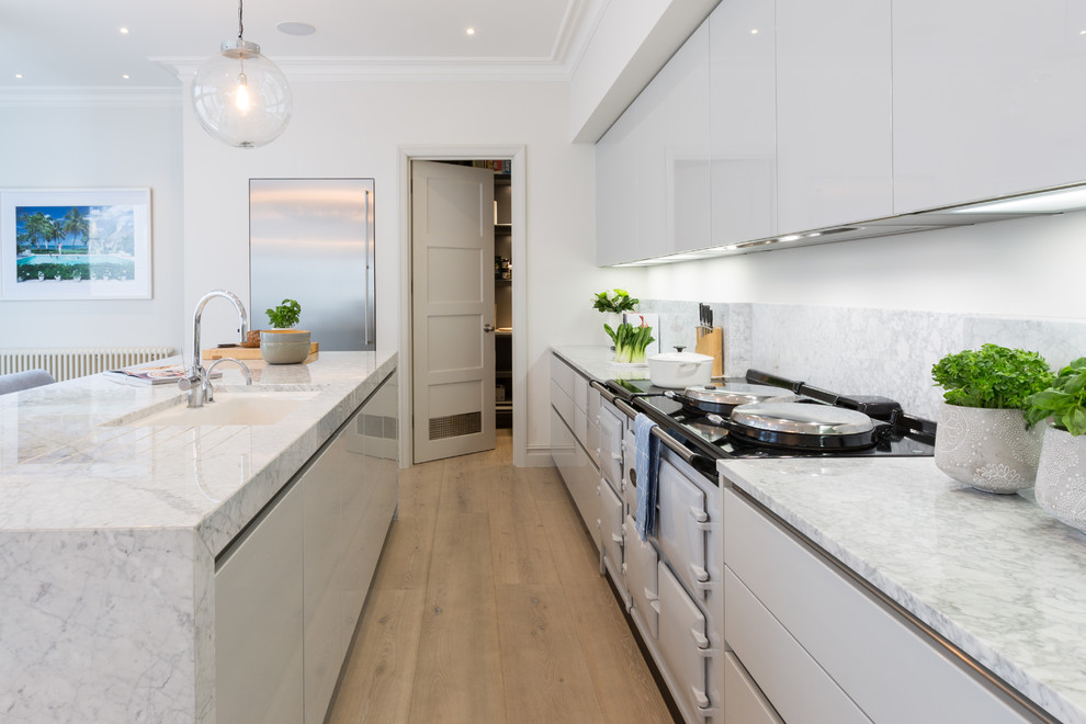 Inspiration for a large contemporary eat-in kitchen in Gloucestershire with an undermount sink, flat-panel cabinets, grey cabinets, marble benchtops, grey splashback, marble splashback, stainless steel appliances, light hardwood floors, with island, brown floor and grey benchtop.