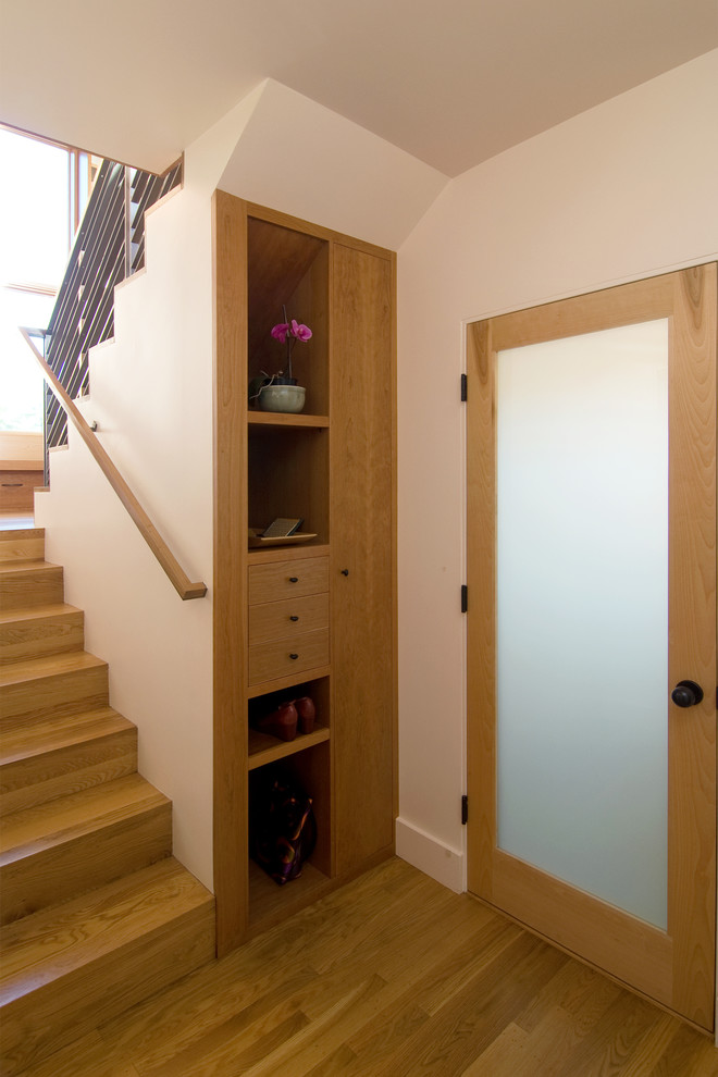 This is an example of a mid-sized contemporary front door in San Francisco with white walls, a single front door, a light wood front door and light hardwood floors.