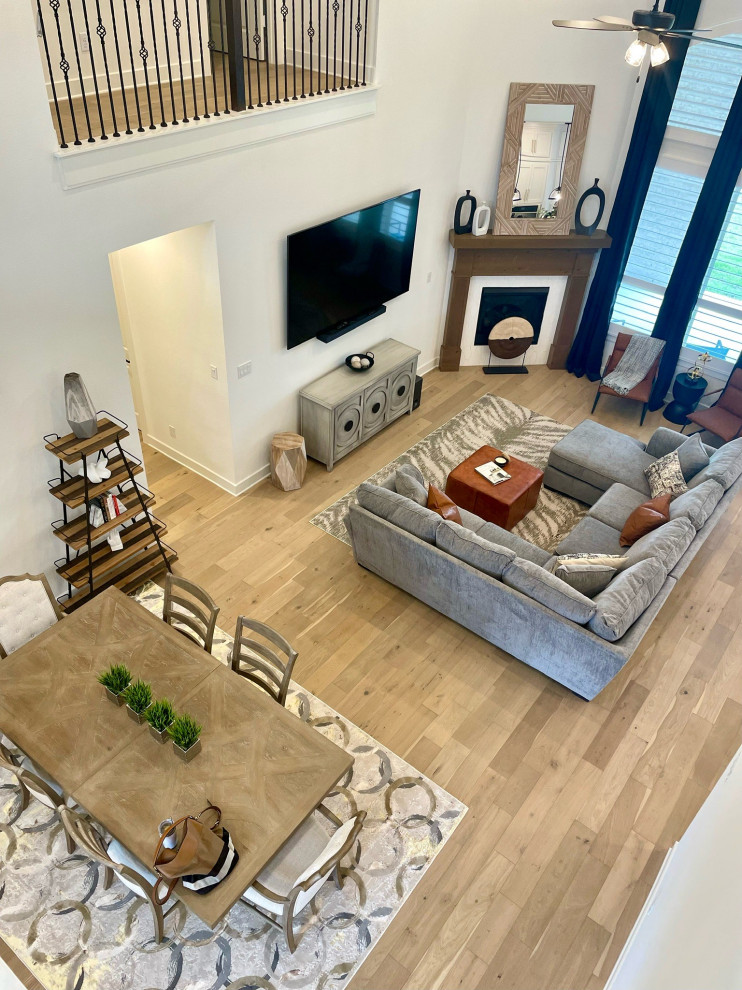 Inspiration for a large modern open concept living room in Other with light hardwood floors and a standard fireplace.