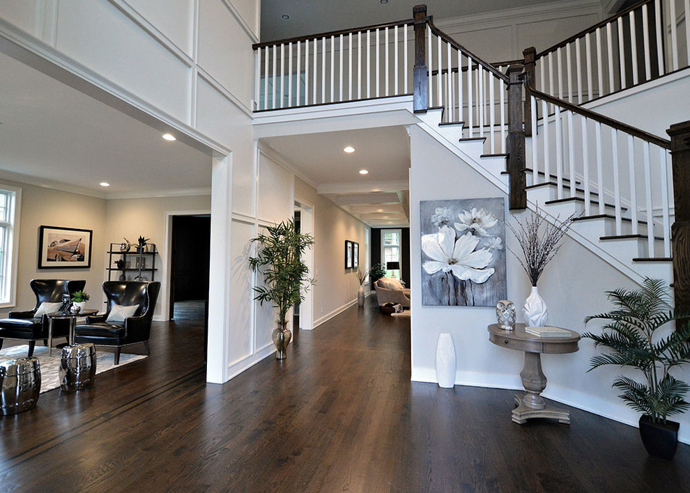 Contemporary foyer in New York with white walls and dark hardwood floors.