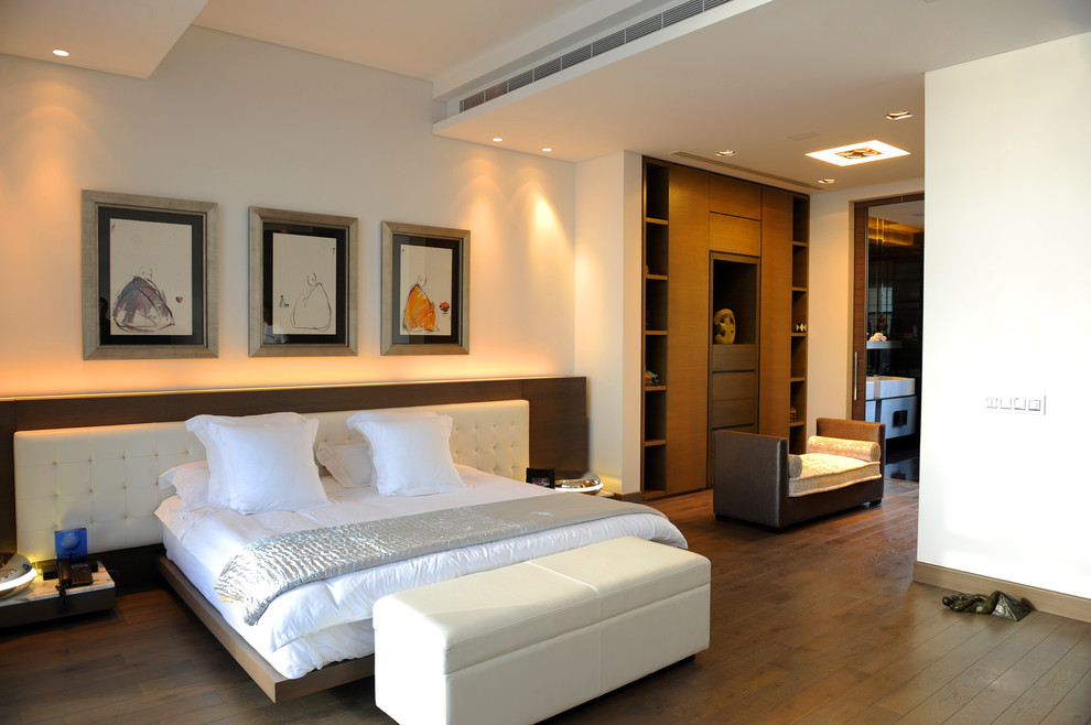 Photo of a contemporary bedroom in Other with beige walls and dark hardwood floors.