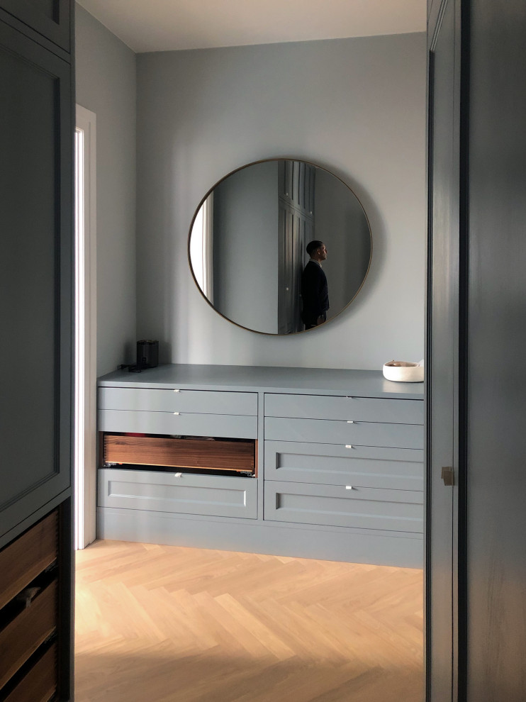 This is an example of a traditional storage and wardrobe in Berlin with beaded inset cabinets and blue cabinets.