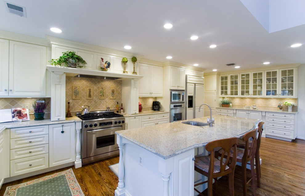 Photo of a traditional kitchen in DC Metro with panelled appliances, raised-panel cabinets, white cabinets and beige splashback.
