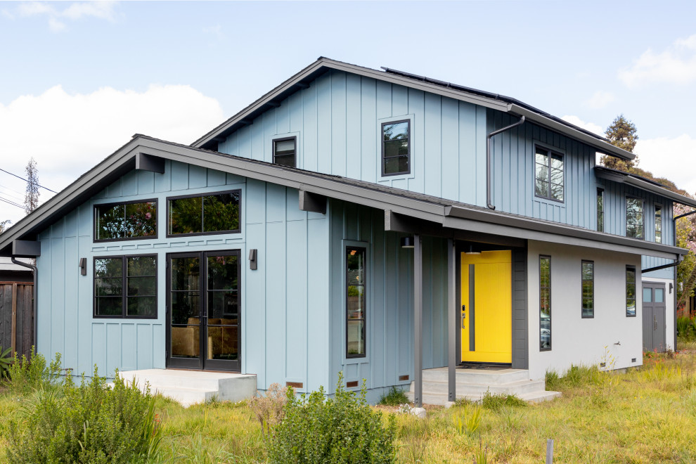 Ispirazione per la villa blu moderna a due piani di medie dimensioni con rivestimento con lastre in cemento, tetto a capanna, copertura a scandole, tetto nero e pannelli e listelle di legno