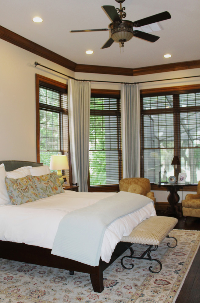 Large traditional master bedroom in Tampa with beige walls and dark hardwood floors.
