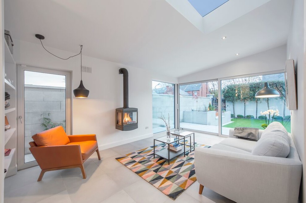 Photo of a medium sized modern enclosed living room with white walls, a wood burning stove and a plastered fireplace surround.