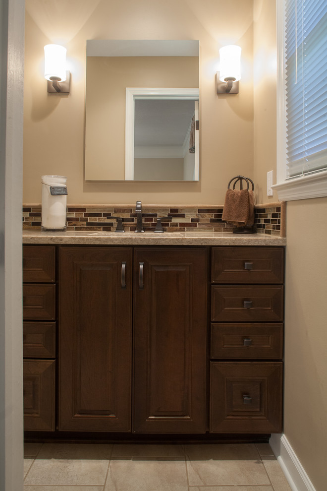 Photo of a transitional bathroom in Kansas City with an undermount sink, medium wood cabinets, engineered quartz benchtops, an alcove shower, beige tile, porcelain tile and porcelain floors.